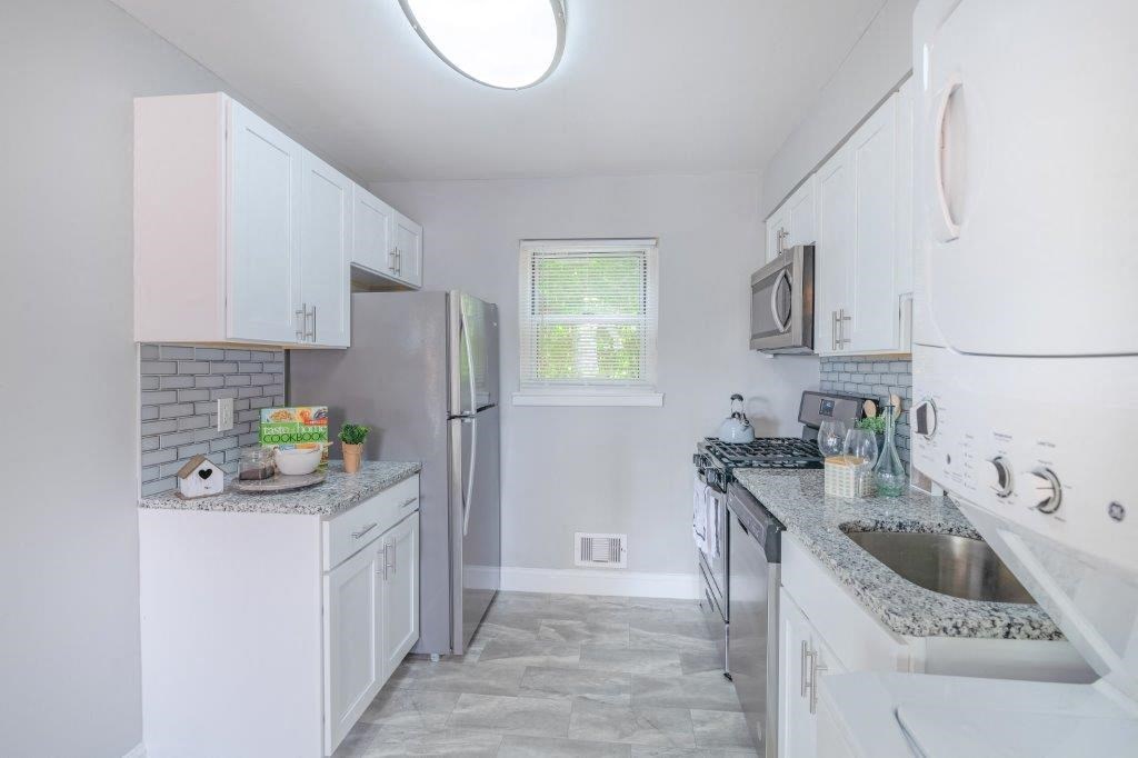 a white kitchen with a sink and a refrigerator