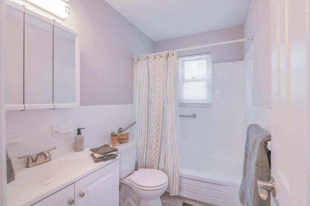 a bathroom with a shower curtain and a toilet and a sink