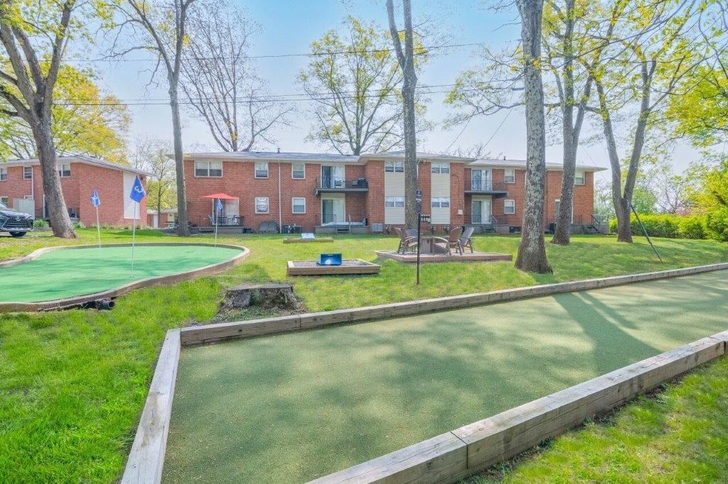a putting green in front of a brick apartment building
