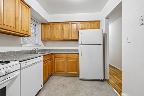 A kitchen with wooden cabinets and white appliances.
