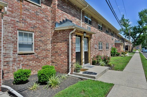 the front of a brick building with a sidewalk in front of it