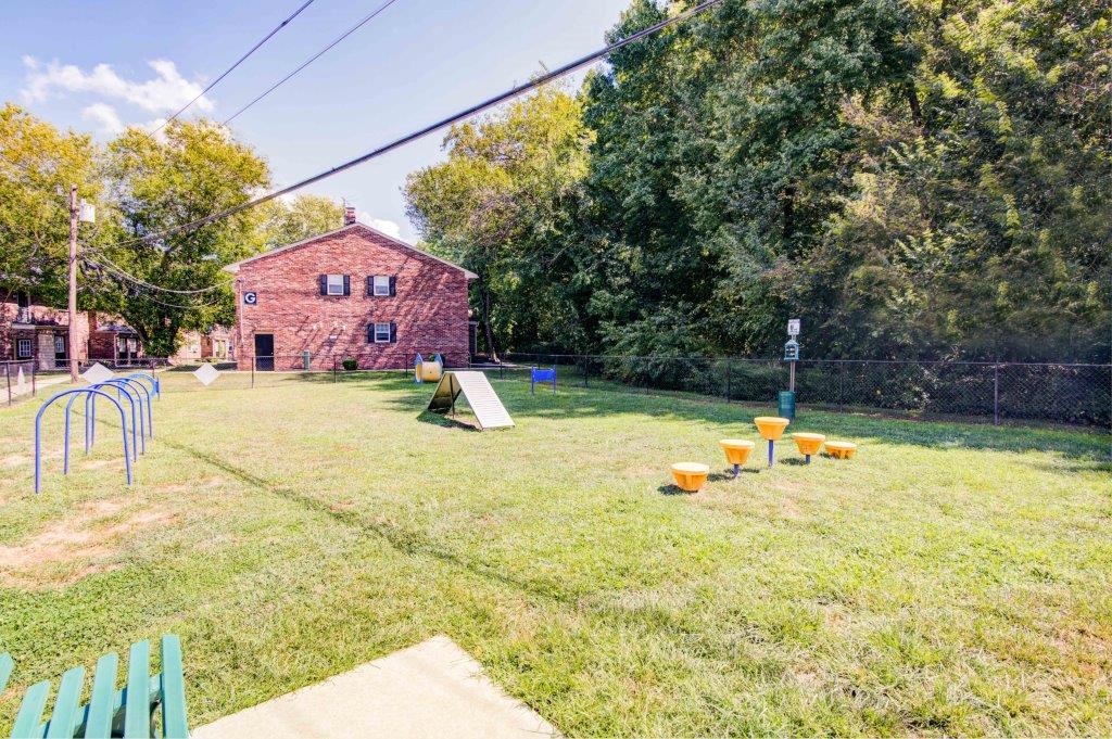 a backyard with a playground and a red brick house