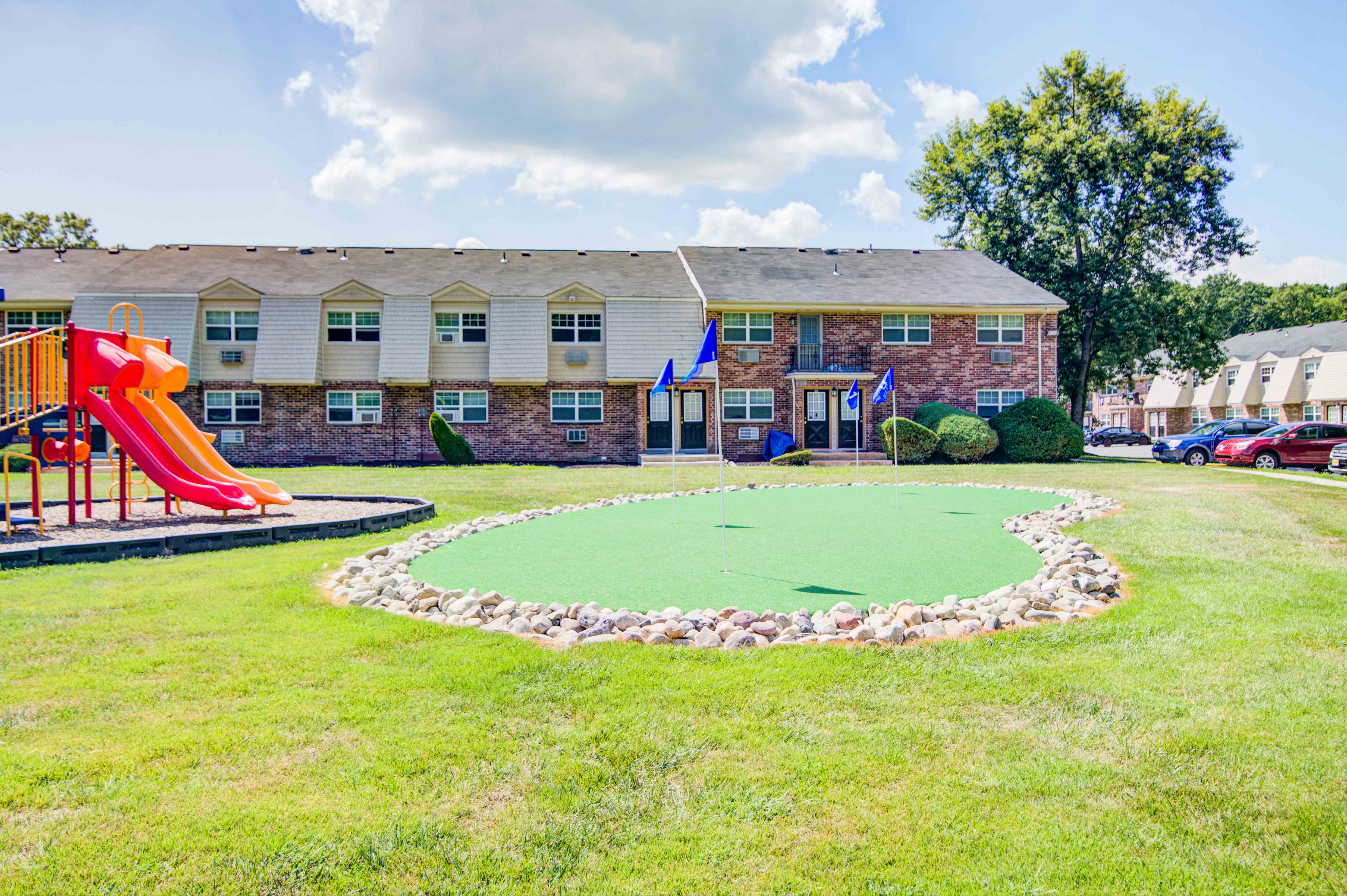 our yard with a playground and our apartments in the background