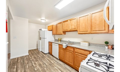 A kitchen with wooden cabinets and a white stove.
