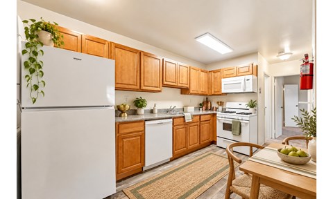 A kitchen with wooden cabinets and a white fridge.
