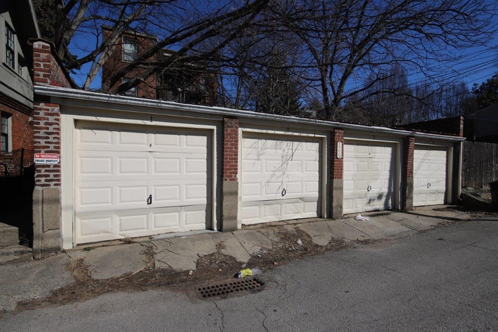 a row of white garage doors on a brick building