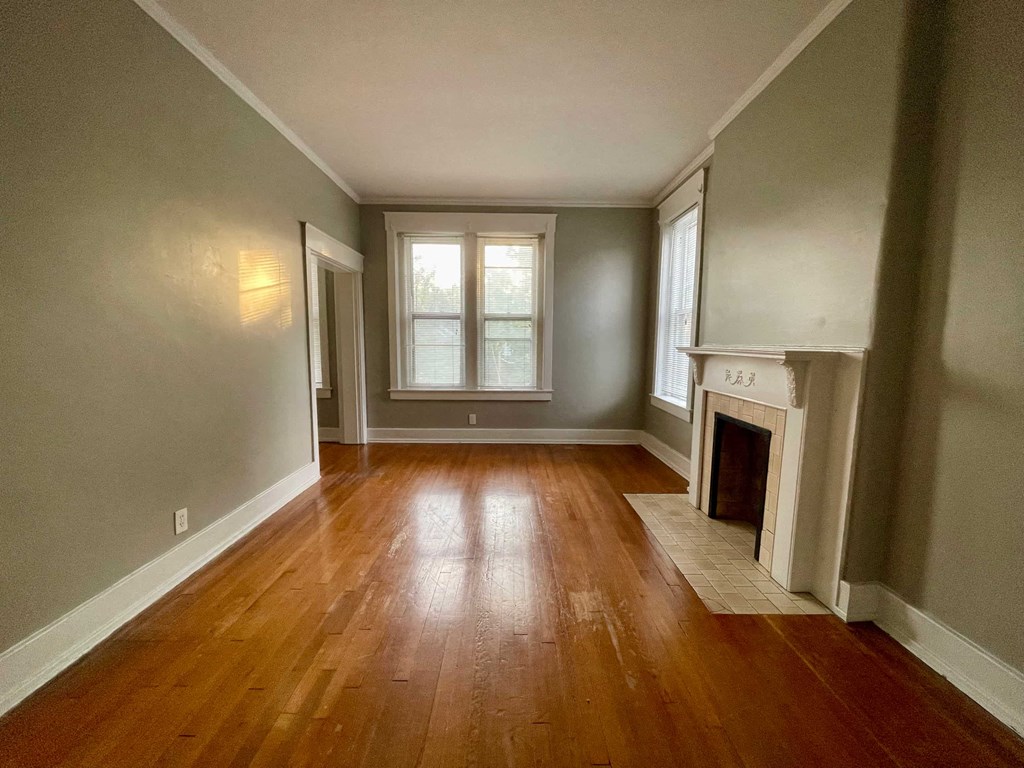 a living room with a fireplace and wooden floors