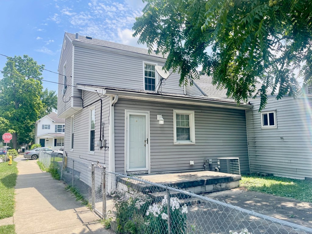 a white house with a white fence and a sidewalk