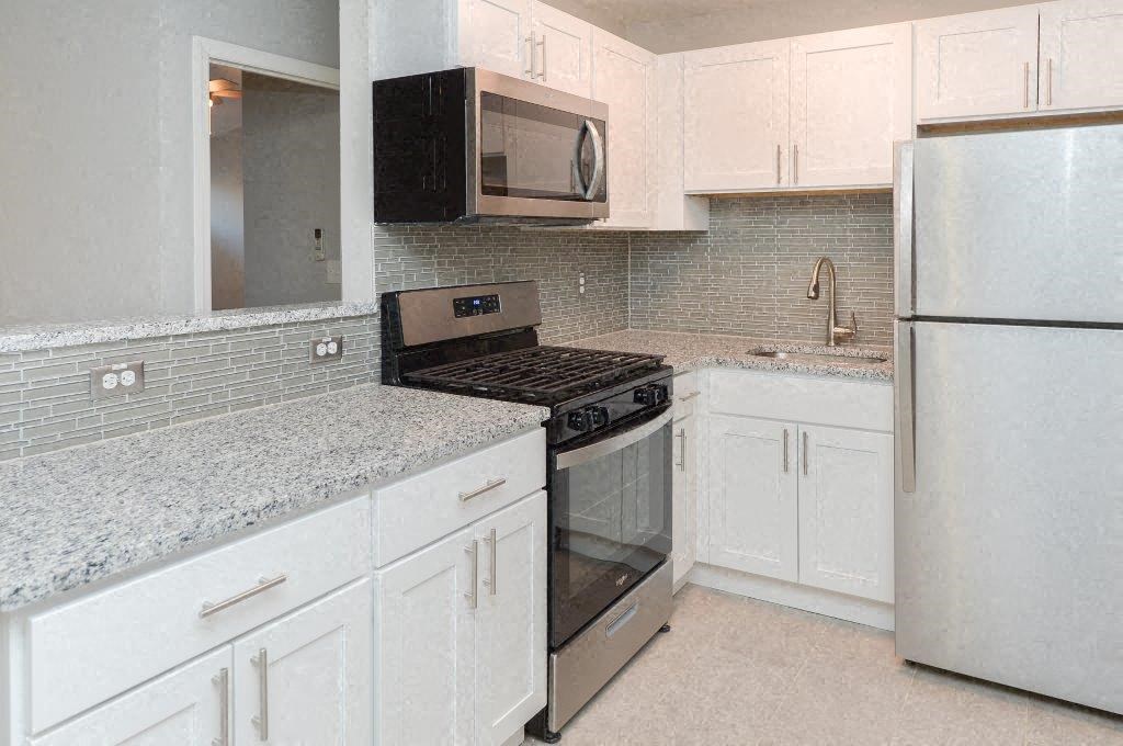 a kitchen with white cabinets and a stove and a refrigerator