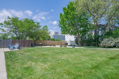 a park with grass and benches in front of a building