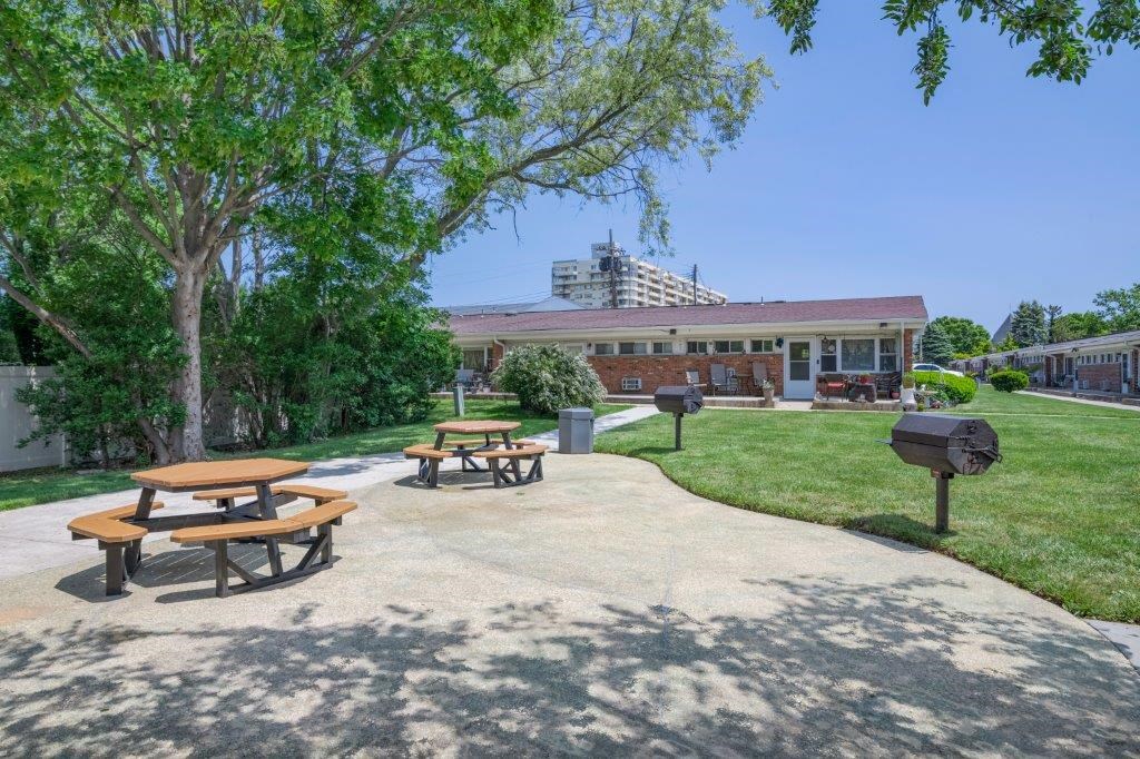 a park with picnic tables and a building in the background