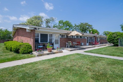 a brick house with a lawn and a sidewalk