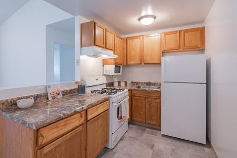 a kitchen with white appliances and wooden cabinets