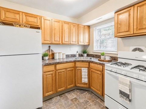 A kitchen with wooden cabinets and a white refrigerator.