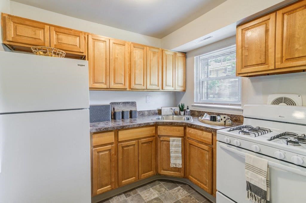 a kitchen with white appliances and wooden cabinets
