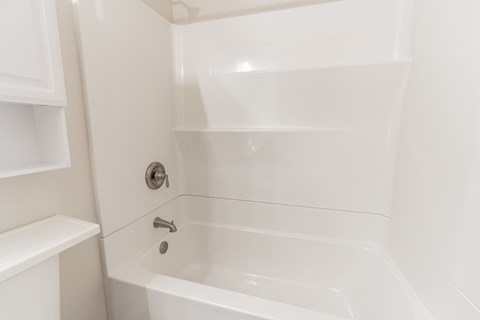 a white bathroom with a tub and a sink