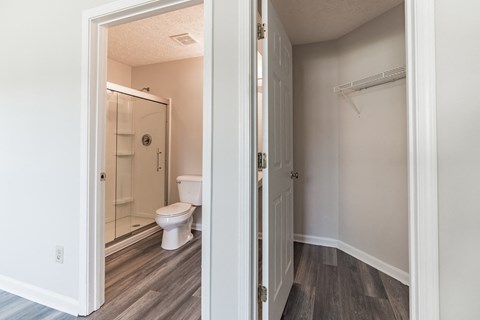 an open door leading to a bathroom with a toilet and shower