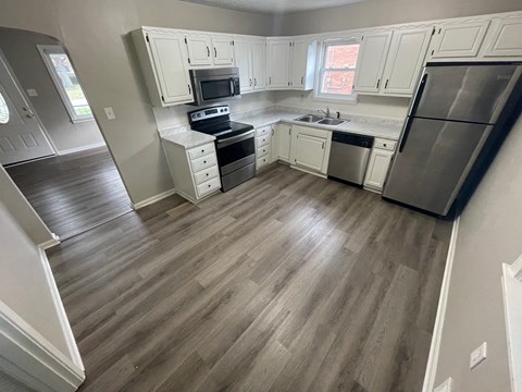 A kitchen with a stove, oven, refrigerator, and sink.