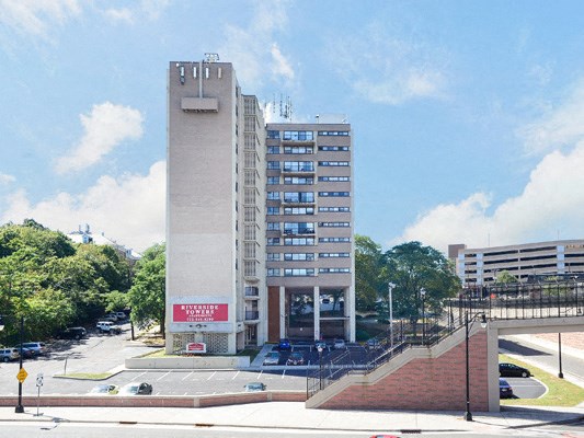 a view of a tall building in front of a parking lot