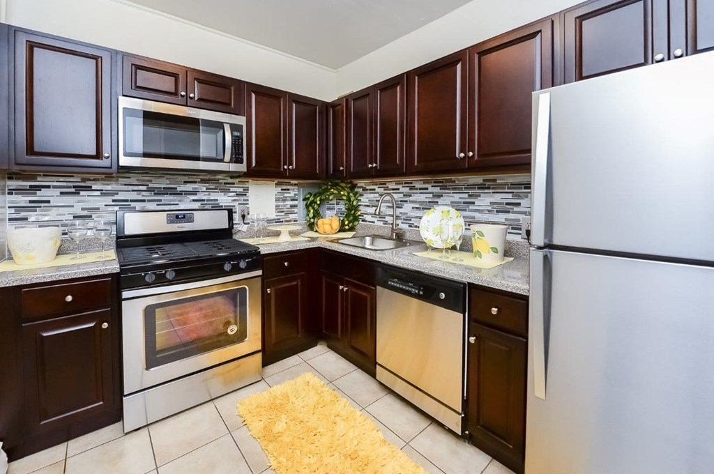 a kitchen with stainless steel appliances and brown cabinets