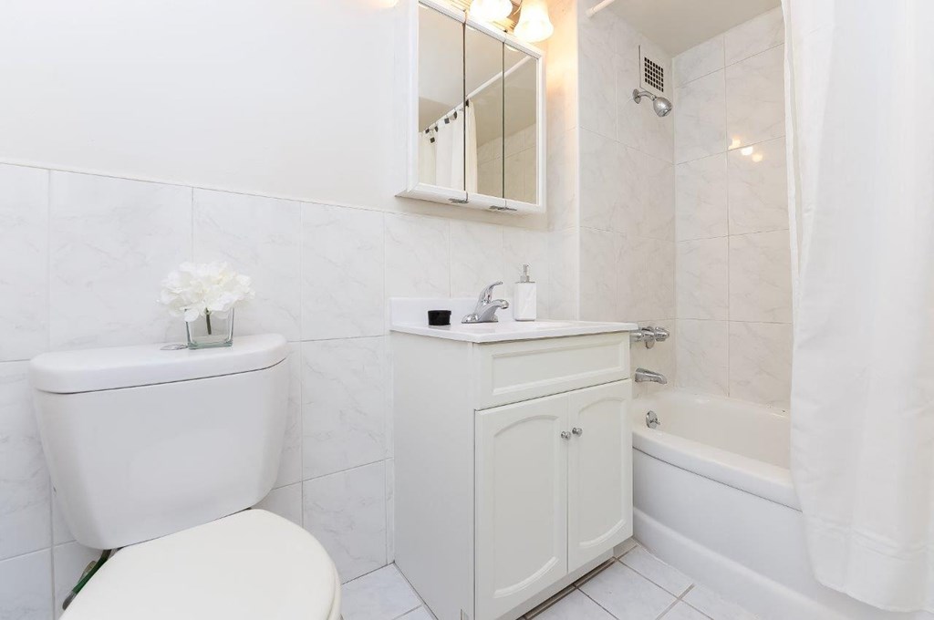 a white bathroom with a toilet and a sink