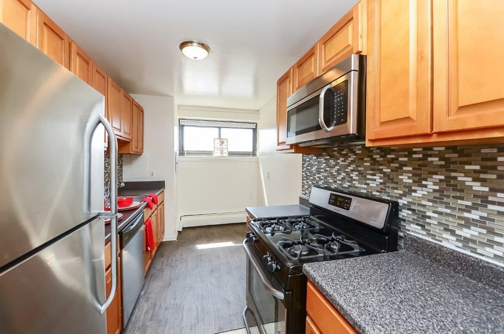 a kitchen with stainless steel appliances and wood cabinets