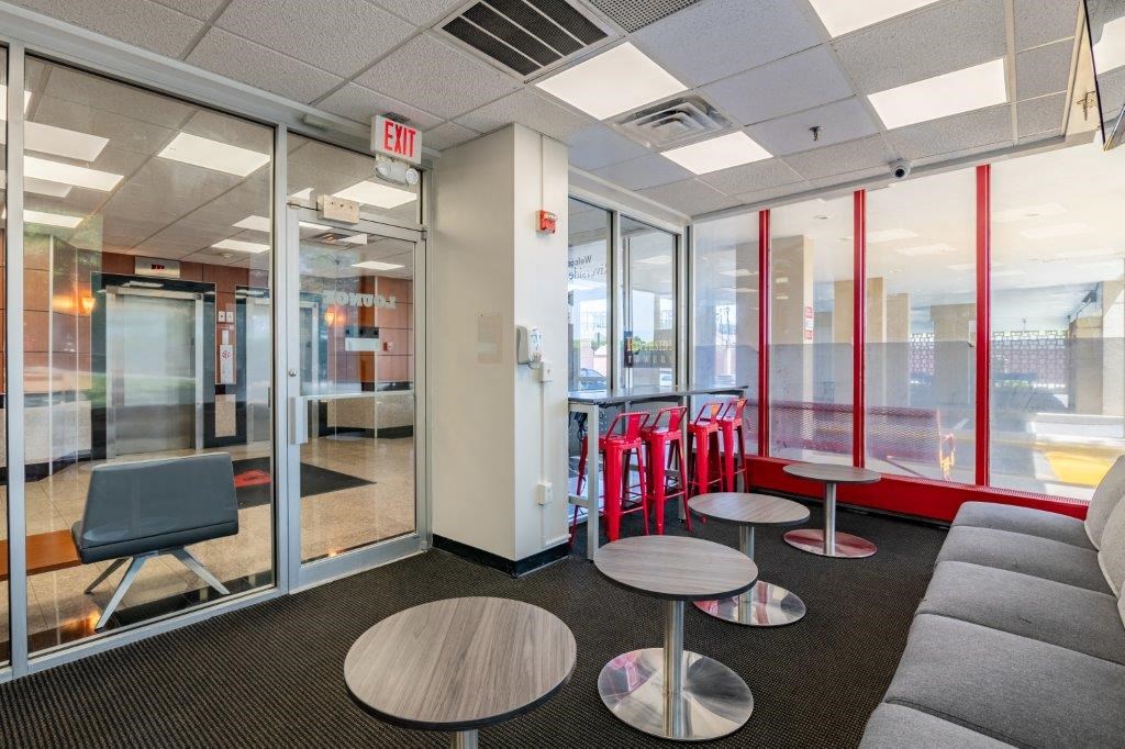 a lounge area with tables and chairs and glass doors