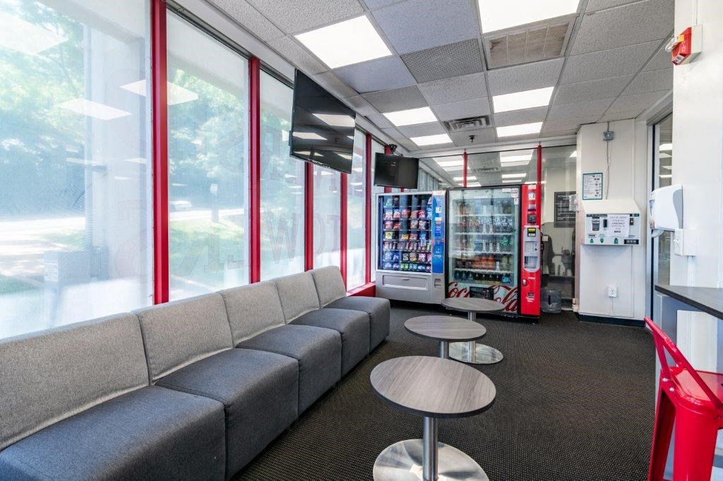 a lounge area with couches and tables and a vending machine