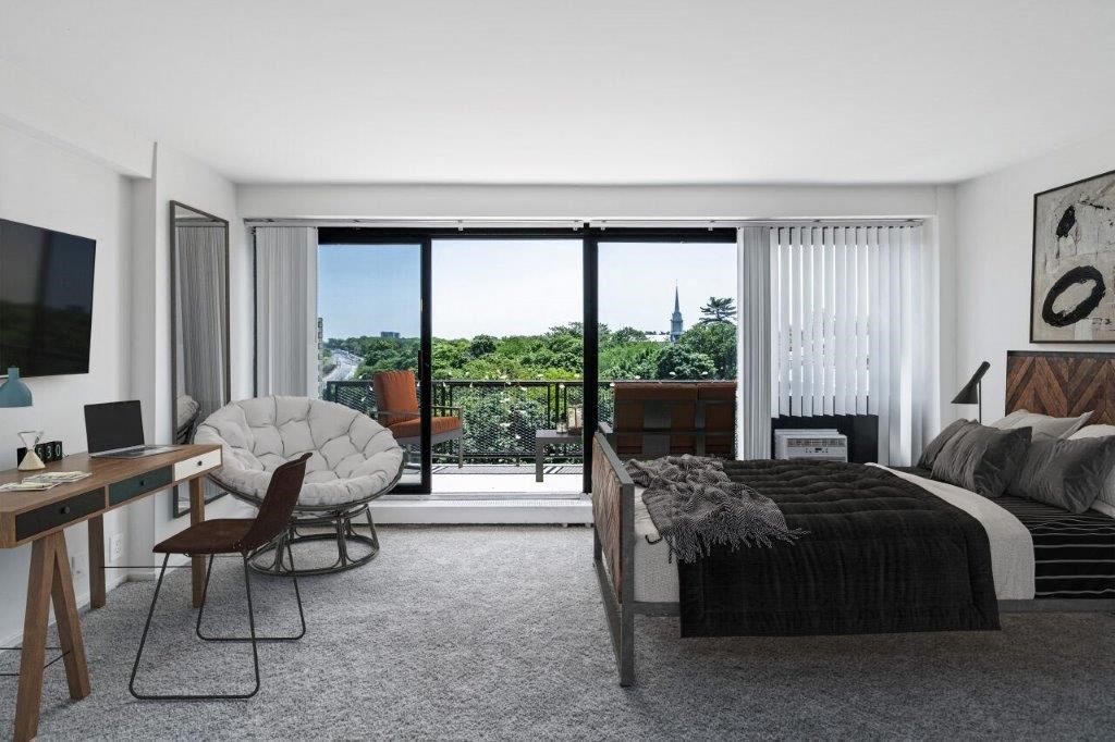 a bedroom with a bed and a desk and a window