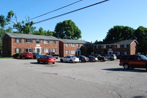 A parking lot with cars and a building in the background.