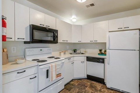 a kitchen with white appliances and white cabinets