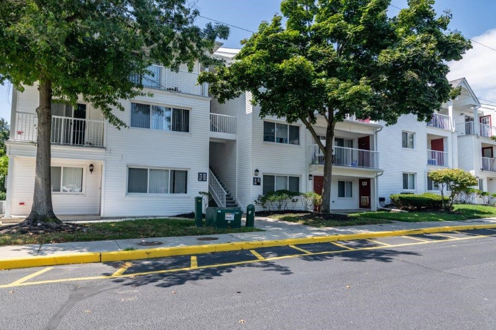 a white apartment building with trees in front of it