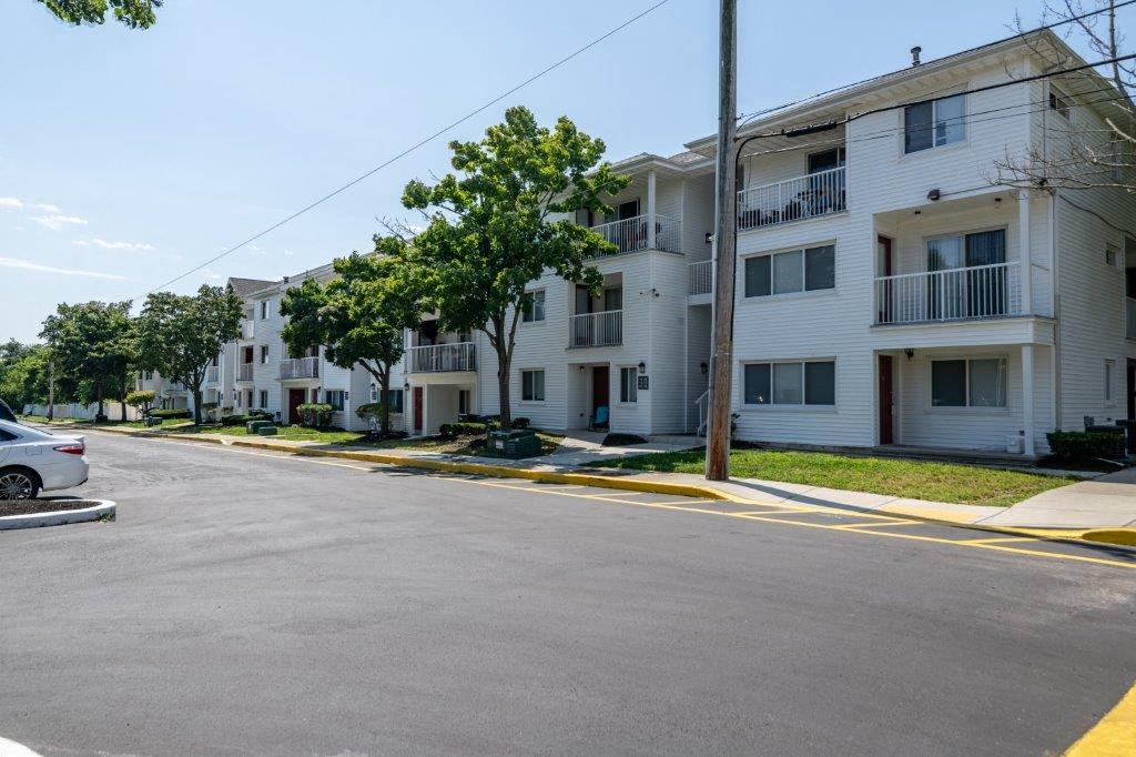 a row of white apartment buildings on the side of a street