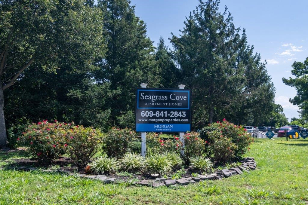 a sign for seagars cove in front of some flowers and trees