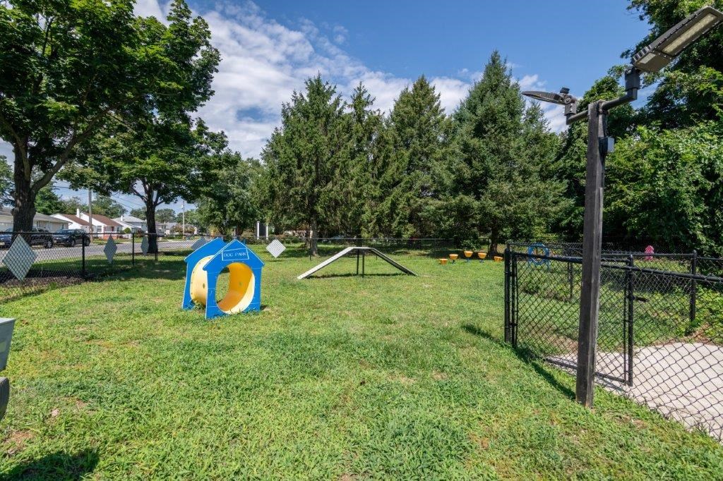 a playground with a slide and a fence in a park