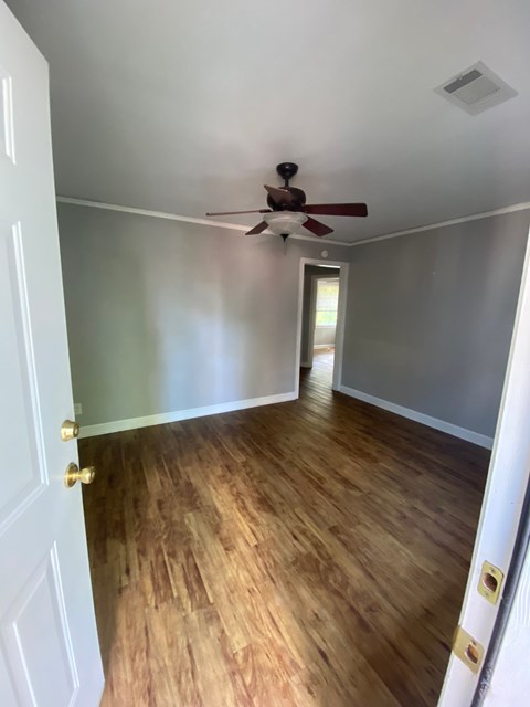 a living room with wood floors and a ceiling fan