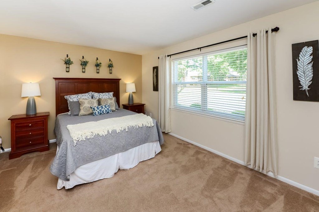 a bedroom with a bed and a large window