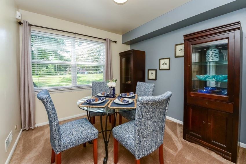 a dining room with a table and chairs and a window