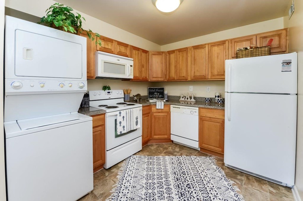 a kitchen with white appliances and wooden cabinets