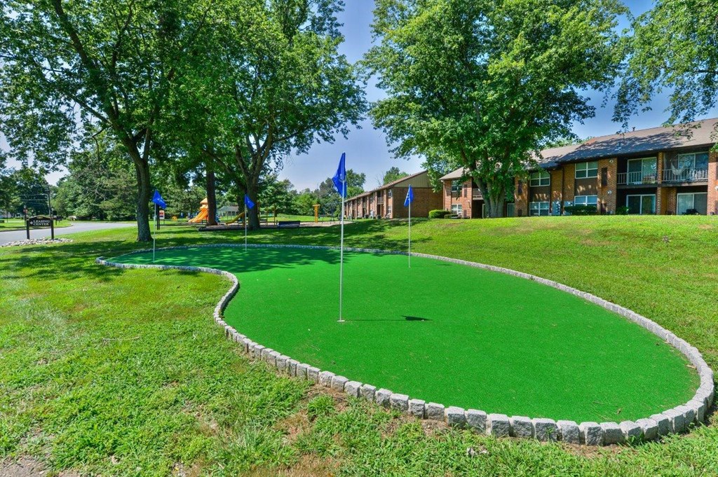 a putting green with flags in front of a building