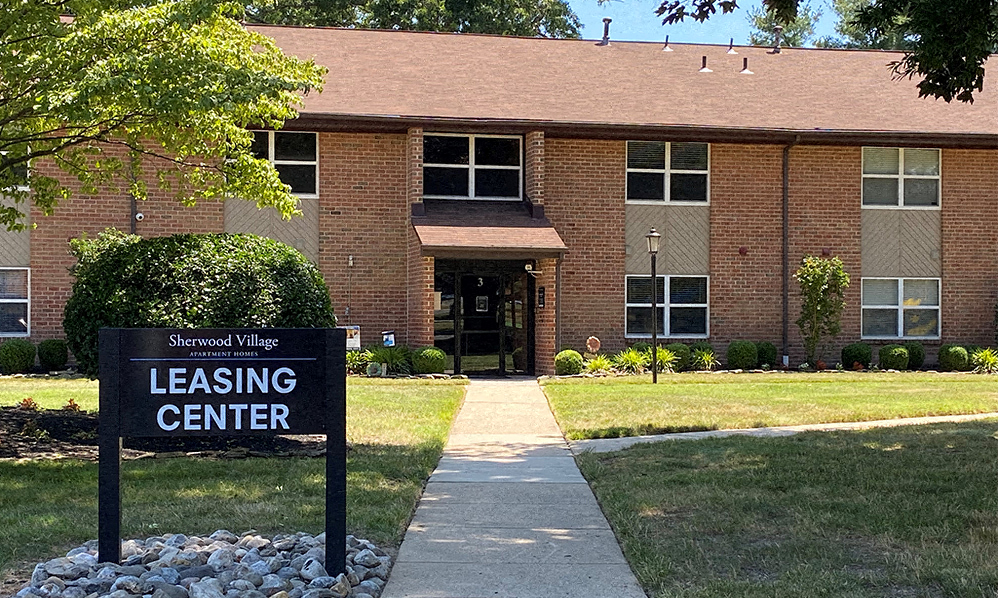 a building with a leasing center sign in front of it