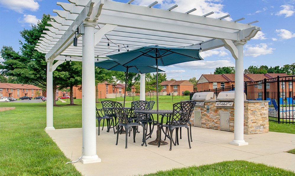 a patio with a table and chairs under an umbrella