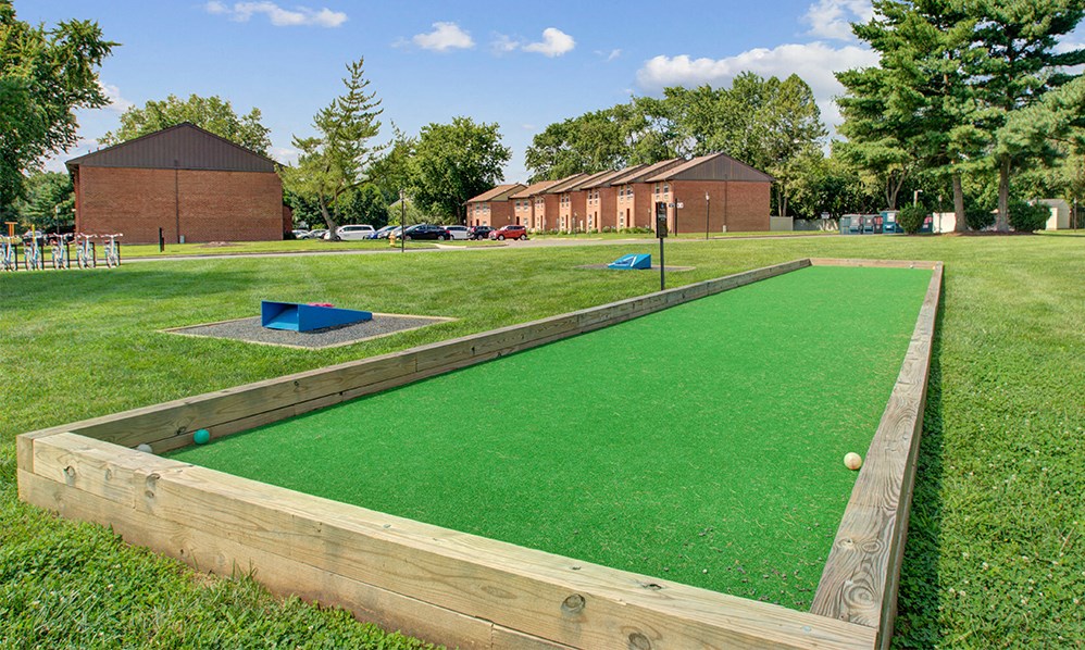 a putting green in the middle of a park with balls on it