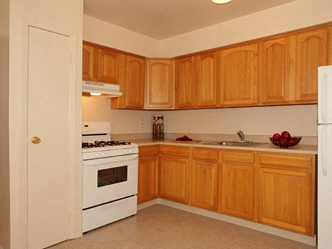 a kitchen with white appliances and wooden cabinets