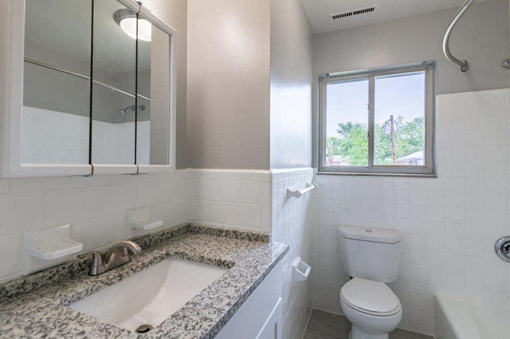 a bathroom with a sink toilet and a window