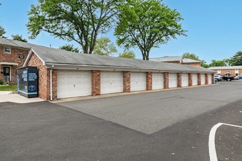 a brick building with white garage doors and a parking lot