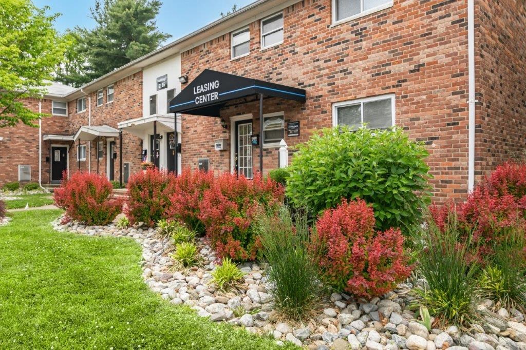 the front of a brick building with a garden in front of it