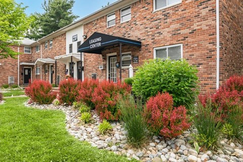 the front of a brick building with a garden in front of it