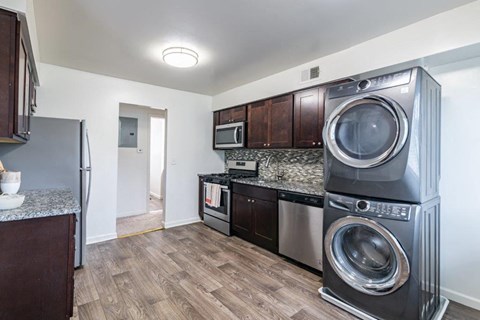 a kitchen with a washing machine and a washer and dryer