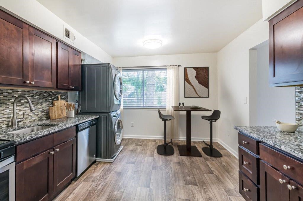 a kitchen with a washer and dryer and a table with chairs